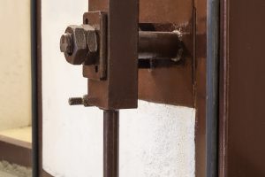 Massive heavy duty air-lock on concrete door in fallout shelter or survival bunker used during war or disaster. Selective focus.